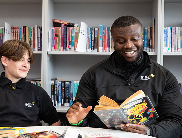 Teaching Assistant reading with a student