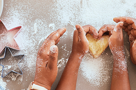 Hands using cookie cutters